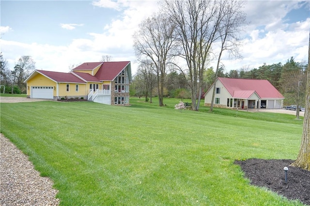 view of yard featuring driveway and a garage
