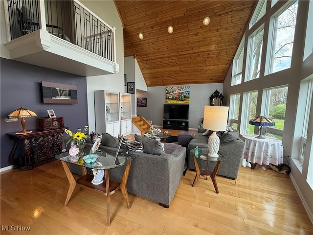 living area with light wood finished floors, baseboards, high vaulted ceiling, and wooden ceiling
