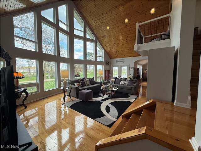 living area with light wood finished floors, high vaulted ceiling, and wood ceiling