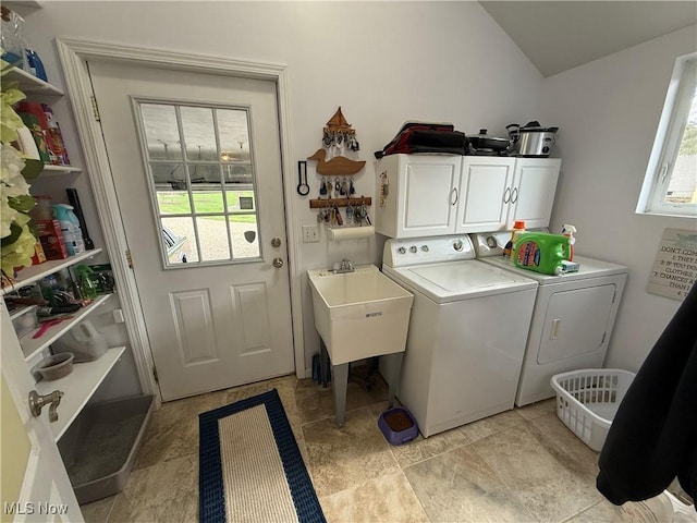 clothes washing area featuring separate washer and dryer, cabinet space, and a sink