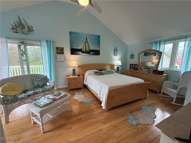 bedroom with high vaulted ceiling, light wood-style flooring, access to outside, and multiple windows