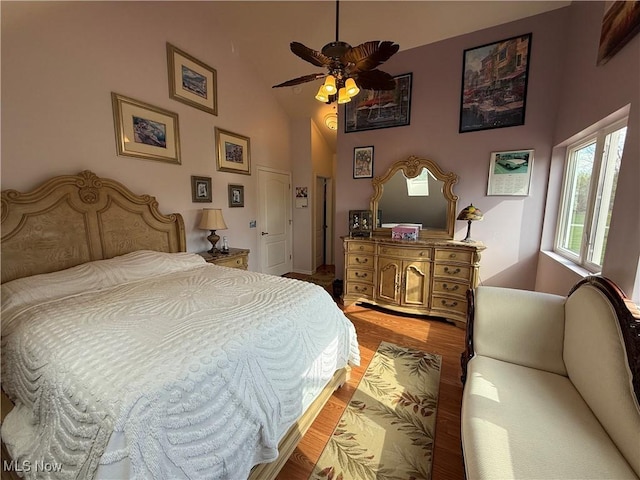 bedroom with a ceiling fan, high vaulted ceiling, and light wood-style flooring