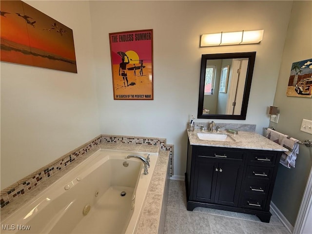 full bathroom with vanity, tile patterned flooring, a jetted tub, and baseboards
