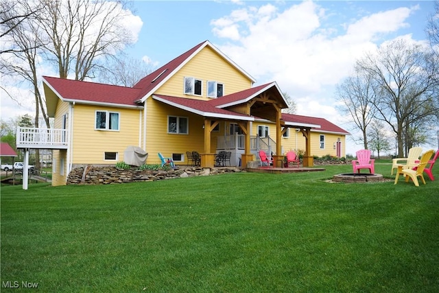rear view of house featuring a lawn, a fire pit, and a patio