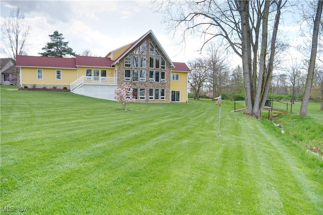 rear view of property with stone siding and a lawn