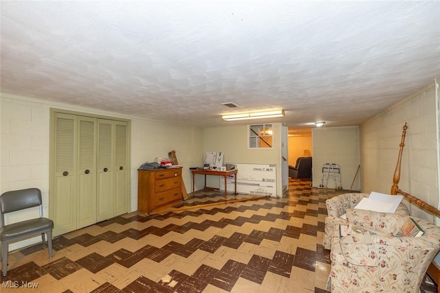 interior space featuring tile patterned floors, visible vents, and concrete block wall