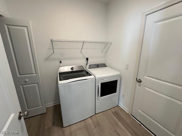 414 Honeycrisp Dr NE, Louisville, OH 44641 - laundry room featuring independent washer and dryer, light wood-style flooring, and baseboards