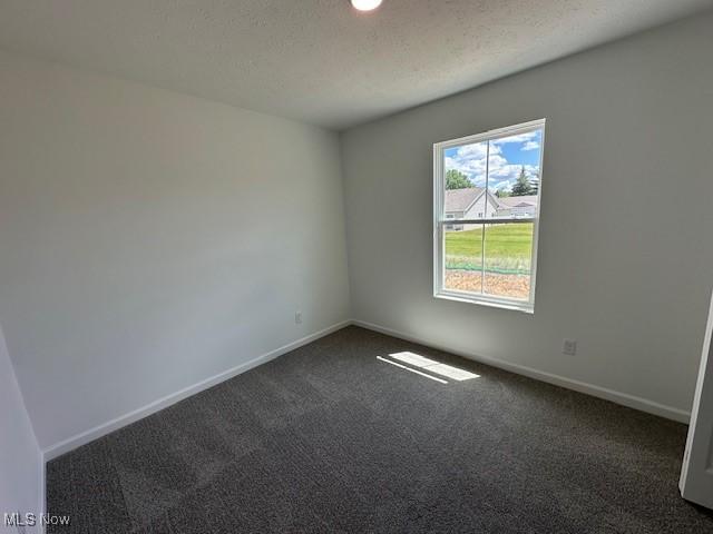 414 Honeycrisp Dr NE, Louisville, OH 44641 - unfurnished room featuring dark carpet, baseboards, recessed lighting, and a textured ceiling