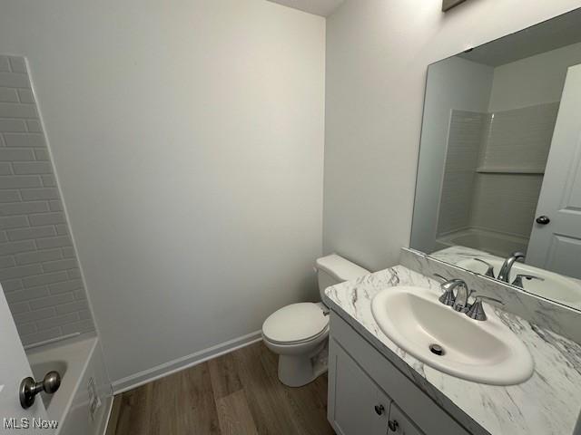 414 Honeycrisp Dr NE, Louisville, OH 44641 - bathroom with wood finished floors, vanity, toilet, shower / bathtub combination, and baseboards