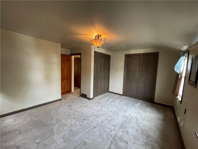 unfurnished bedroom featuring baseboards and light colored carpet