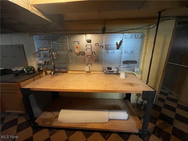 unfinished basement with a workshop area and tile patterned floors