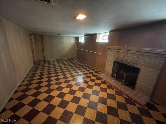 basement featuring tile patterned floors and a fireplace