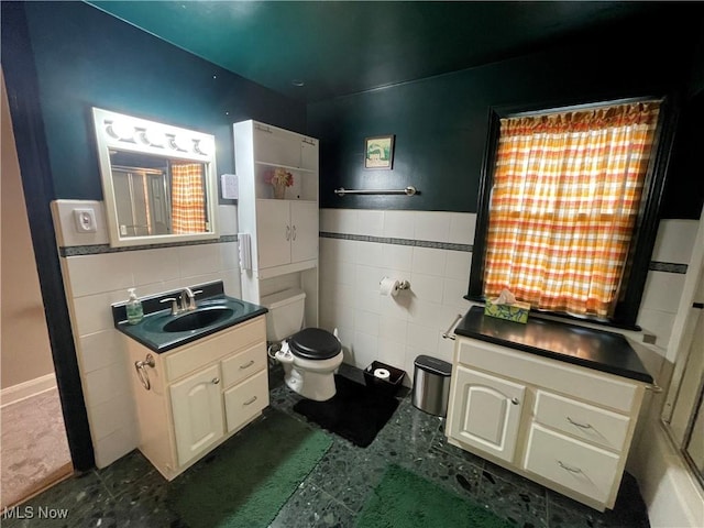 bathroom featuring tile walls, toilet, and vanity