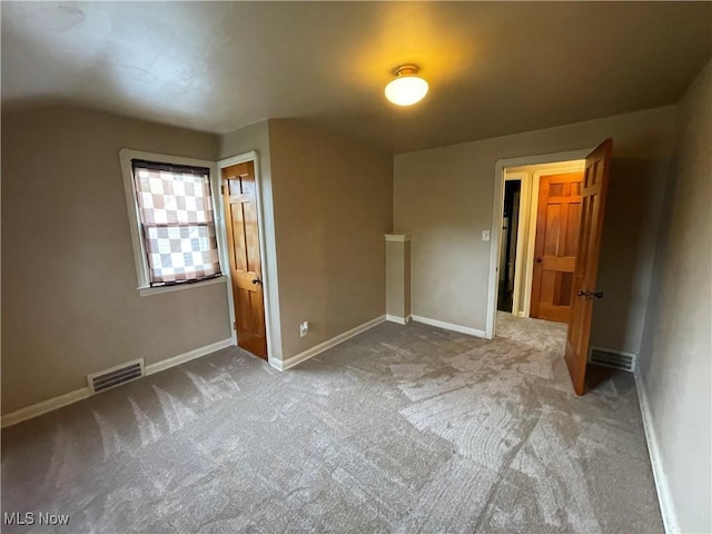 unfurnished bedroom with carpet flooring, visible vents, and baseboards