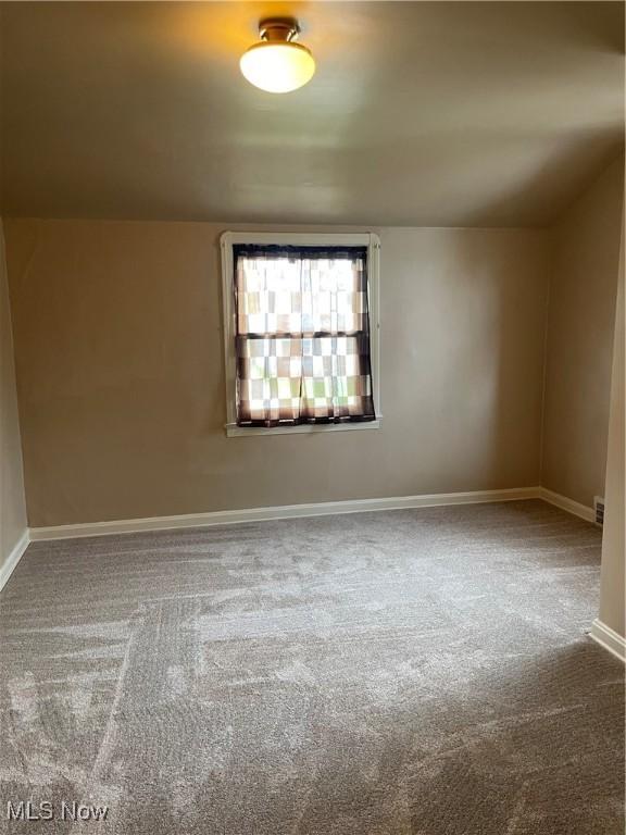 unfurnished room with carpet and baseboards