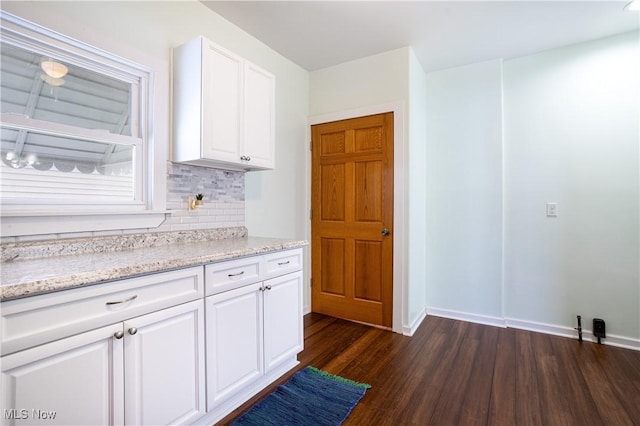 9612 Park Heights Ave, Garfield Heights, OH 44125 - kitchen featuring dark wood finished floors, tasteful backsplash, light stone countertops, white cabinets, and baseboards