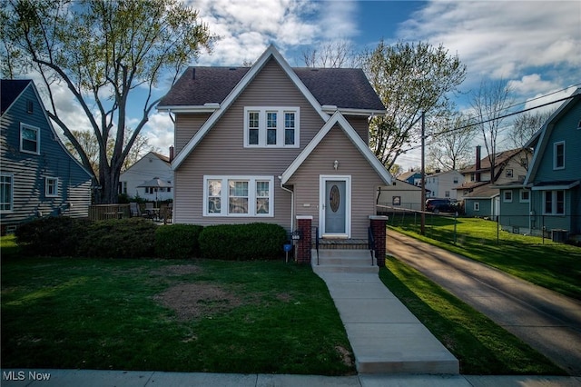 view of front of house with fence and a front lawn