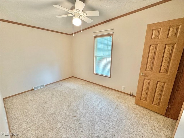 unfurnished room featuring carpet flooring, baseboards, visible vents, a ceiling fan, and a textured ceiling