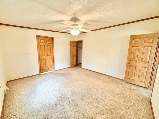 unfurnished room featuring a ceiling fan, a textured ceiling, light colored carpet, and baseboards