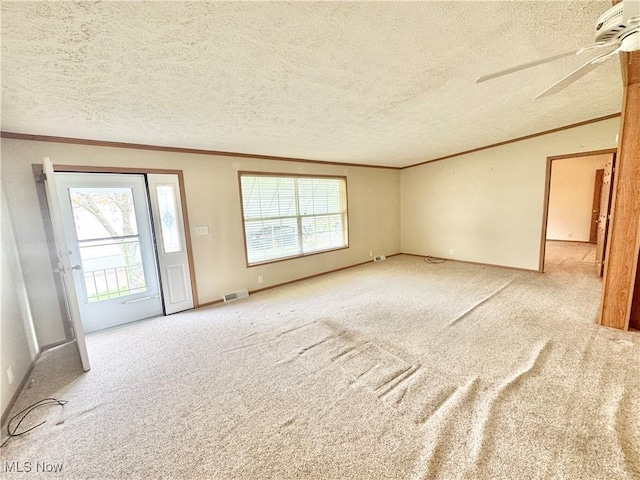 spare room featuring crown molding, a textured ceiling, carpet flooring, and visible vents