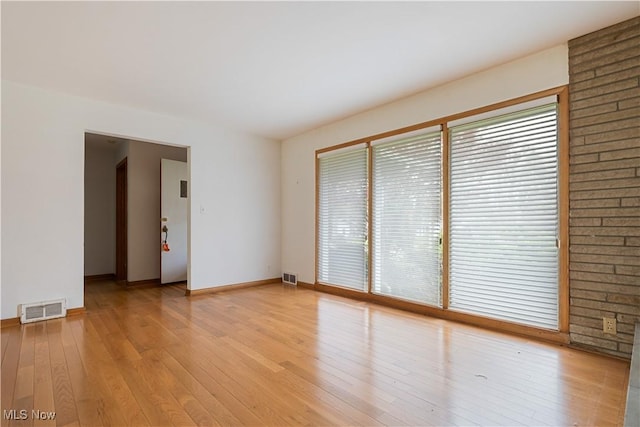 spare room with visible vents, light wood-type flooring, and baseboards