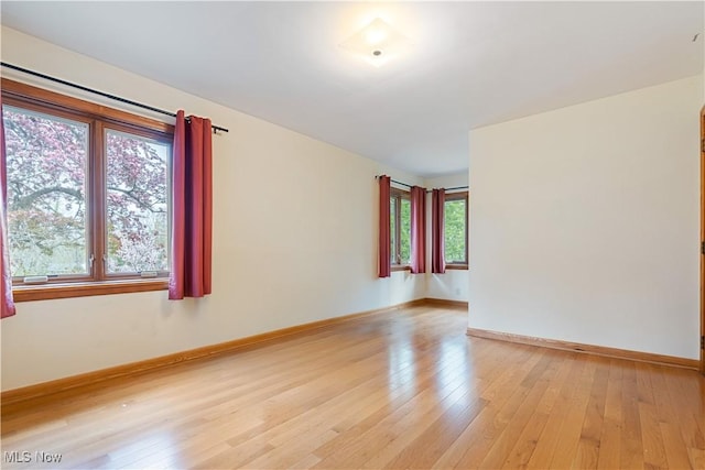 empty room with light wood-style flooring and baseboards