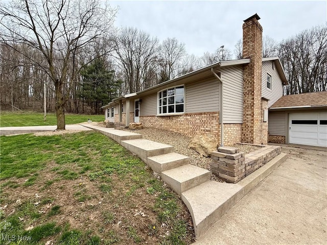 83 Oneida Trl, Malvern, OH 44644 - view of property exterior with concrete driveway, a chimney, an attached garage, a yard, and brick siding