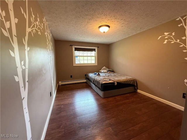 83 Oneida Trl, Malvern, OH 44644 - bedroom featuring a textured ceiling, wood finished floors, baseboard heating, and baseboards