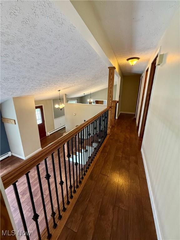 83 Oneida Trl, Malvern, OH 44644 - hall featuring a textured ceiling, baseboards, a notable chandelier, and wood-type flooring
