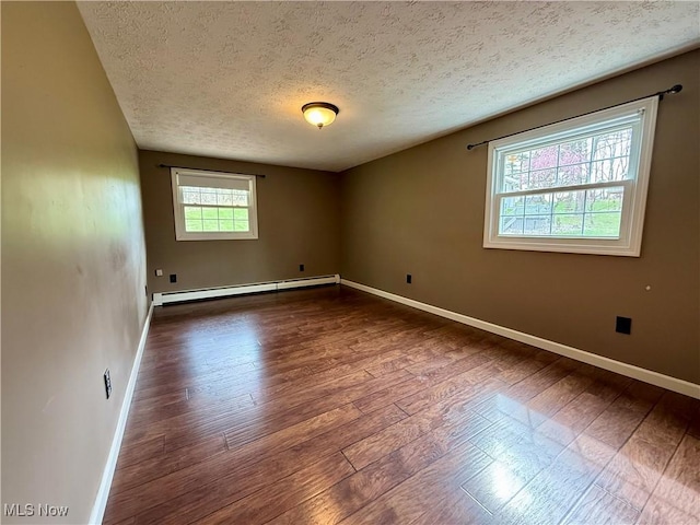 83 Oneida Trl, Malvern, OH 44644 - empty room featuring a textured ceiling, dark wood-style flooring, baseboard heating, and baseboards