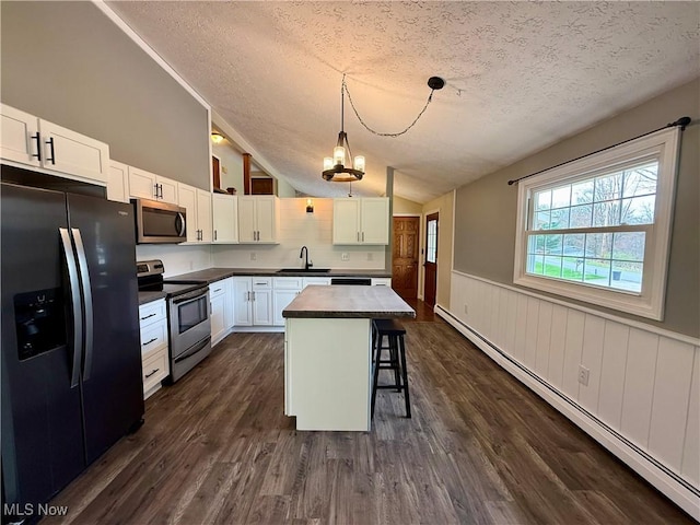 83 Oneida Trl, Malvern, OH 44644 - kitchen with a sink, a textured ceiling, appliances with stainless steel finishes, lofted ceiling, and a baseboard radiator