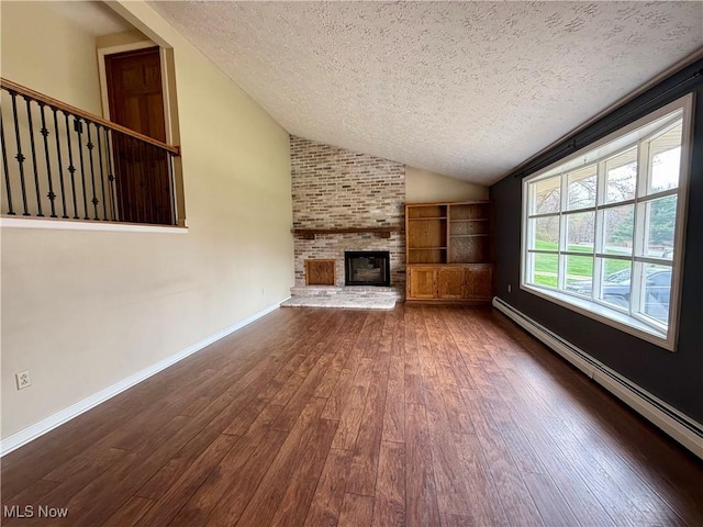 83 Oneida Trl, Malvern, OH 44644 - unfurnished living room featuring lofted ceiling, a textured ceiling, a baseboard radiator, wood-type flooring, and a fireplace