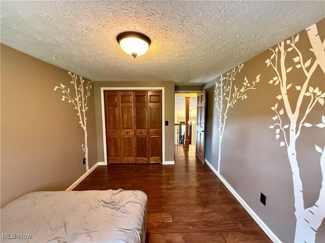 83 Oneida Trl, Malvern, OH 44644 - bedroom featuring baseboards, wood finished floors, a textured ceiling, and a closet