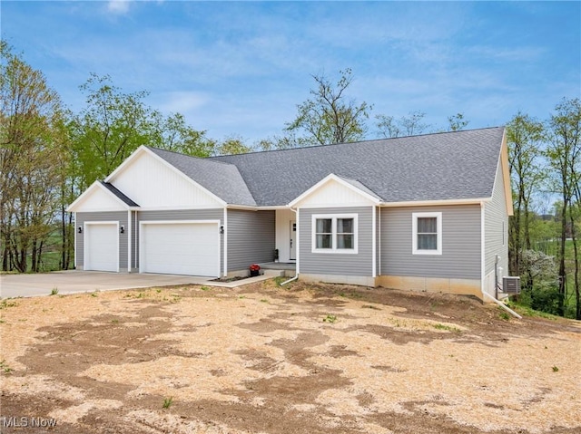 ranch-style home with concrete driveway, a shingled roof, an attached garage, and central AC unit
