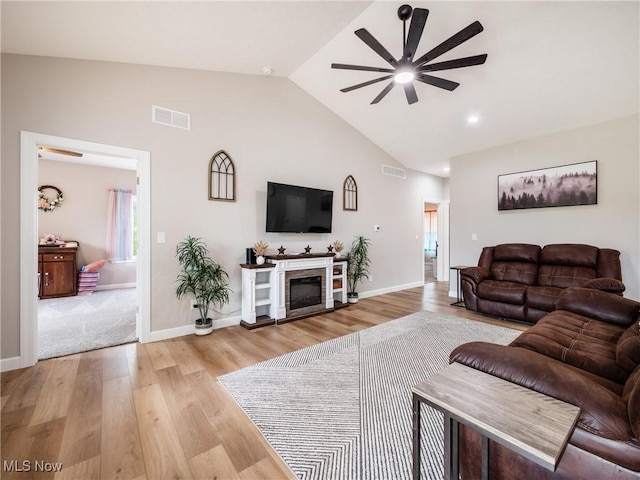 living room featuring light wood finished floors, visible vents, and ceiling fan