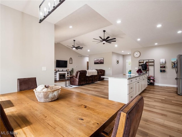 dining area with recessed lighting, a ceiling fan, light wood-style flooring, and vaulted ceiling