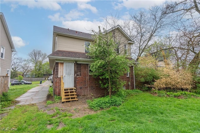 708 Moreley Ave, Akron, OH 44320 - rear view of house featuring a lawn, entry steps, and brick siding