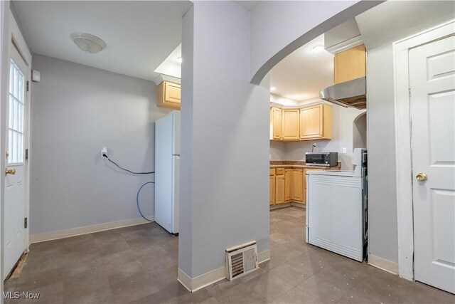 708 Moreley Ave, Akron, OH 44320 - kitchen featuring stainless steel microwave, under cabinet range hood, light brown cabinetry, visible vents, and freestanding refrigerator