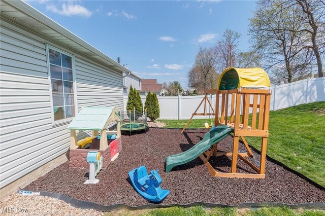 view of playground with a lawn and a fenced backyard