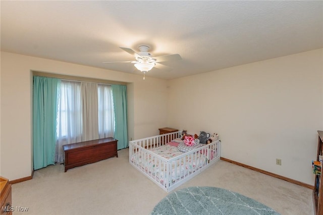 carpeted bedroom with baseboards and a ceiling fan
