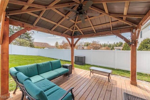wooden terrace featuring ceiling fan, a fenced backyard, a lawn, an outdoor hangout area, and a gazebo
