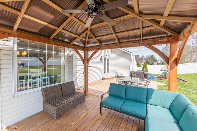 deck with an outdoor living space, a gazebo, fence, outdoor dining space, and a ceiling fan