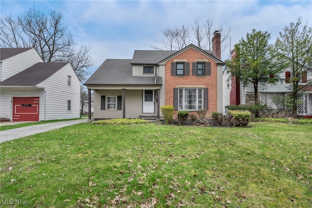 traditional home with a front yard, driveway, an attached garage, and a chimney