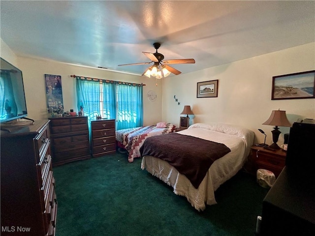 bedroom with a ceiling fan and dark colored carpet