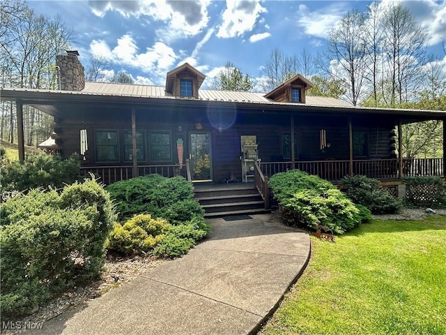 view of front of home featuring a porch, log siding, metal roof, and a chimney