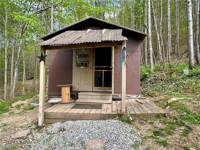 view of outbuilding featuring a view of trees and an outbuilding