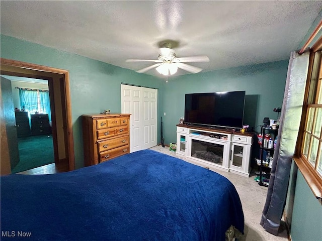 bedroom with carpet floors, a textured ceiling, and ceiling fan