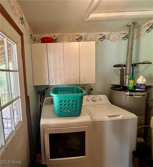 clothes washing area featuring separate washer and dryer and cabinet space