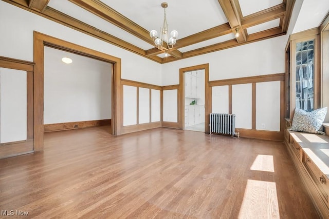 1357 E Blvd Unit 2, Cleveland, OH 44106 - unfurnished living room featuring coffered ceiling, a notable chandelier, radiator heating unit, and light wood-style flooring