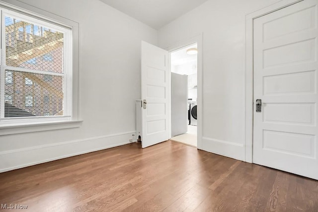 1357 E Blvd Unit 2, Cleveland, OH 44106 - unfurnished bedroom with multiple windows, baseboards, wood finished floors, and washer / clothes dryer